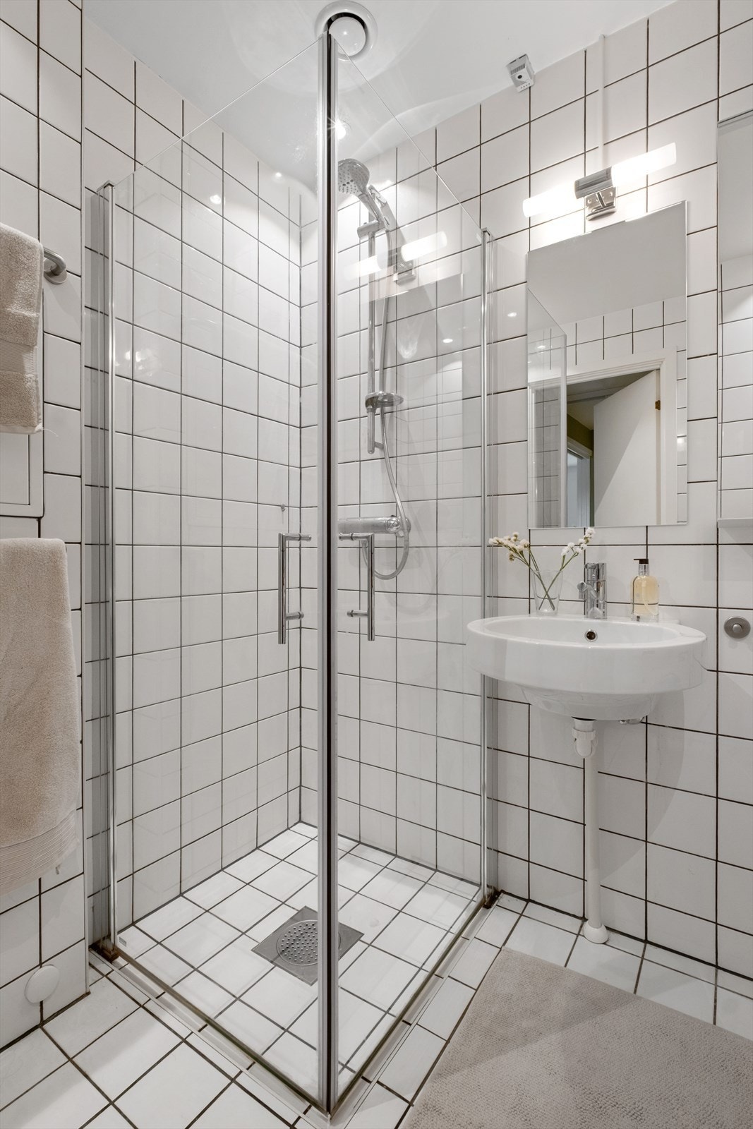 Badet er innredet med toalett, servant, speil og dusjhjørne med svingbare glassdører. Galleribilde