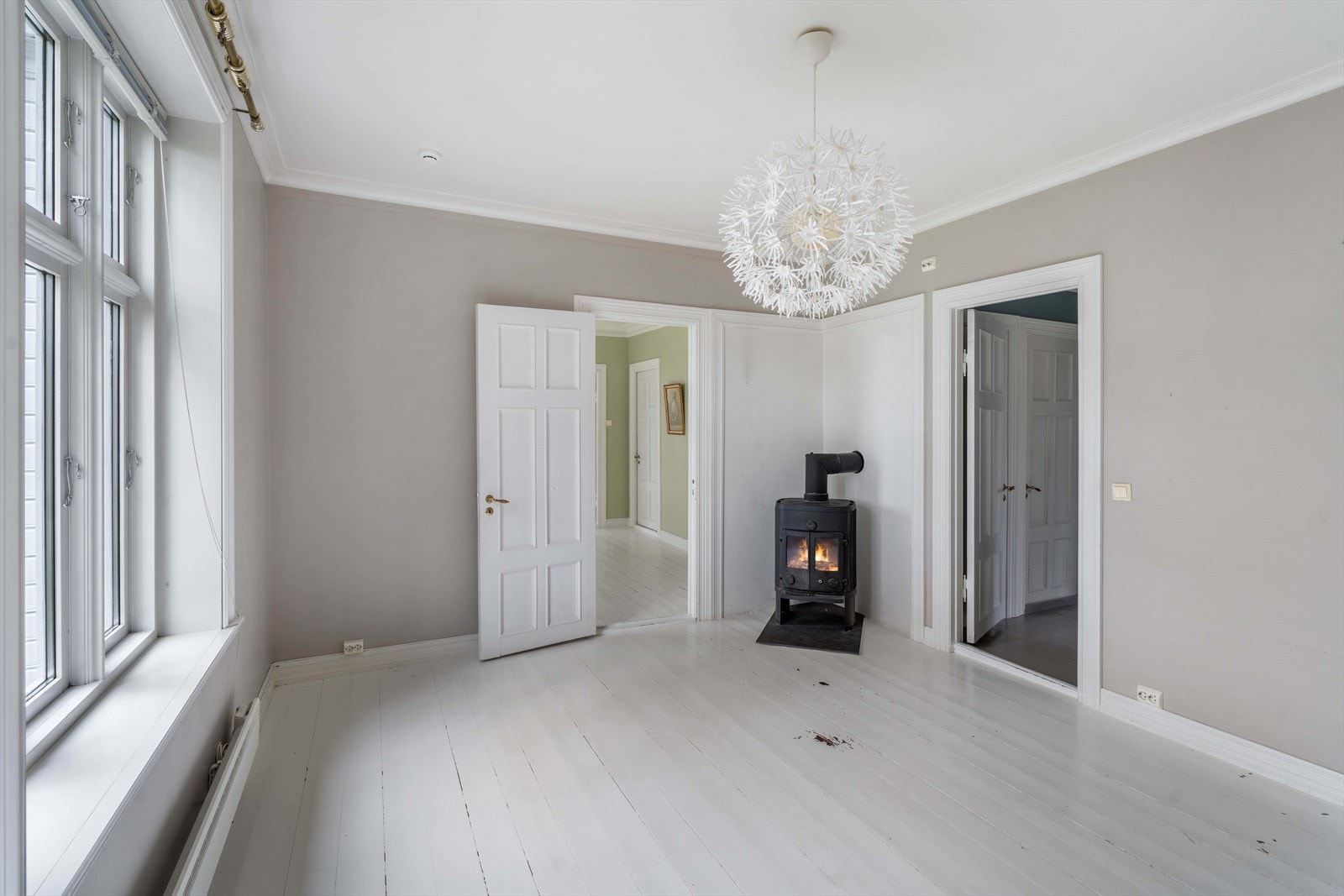 Stue 3 med vedovn hvor man går videre inn til kjøkken Galleribilde