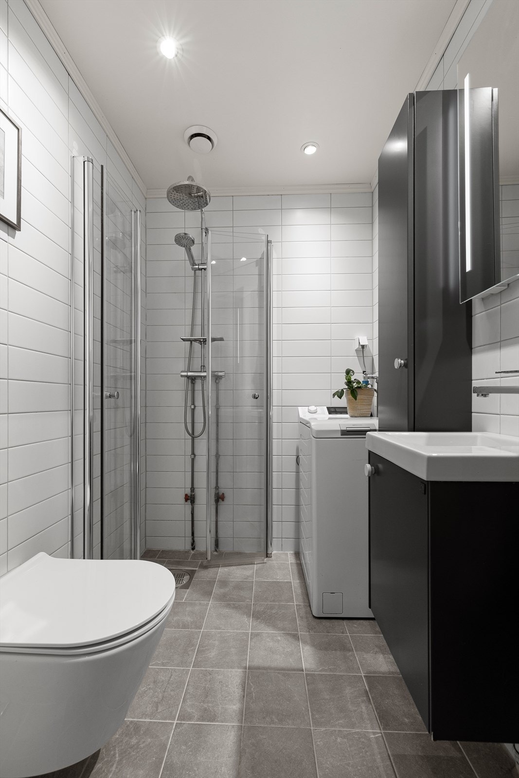 Utstyrt med naturlig avtrekk, opplegg for vaskemaskin, innfellbare dusjdører, veggmontert wc og servantskap med ett greps blandebatteri fra Tapwell. Galleribilde