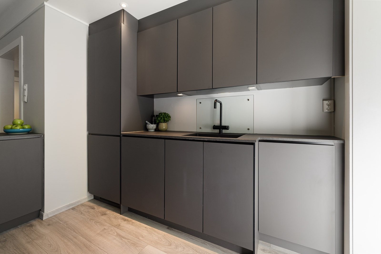 Innredning med kullfiltervifte over stekesonen. Det er integrert kjøl/fryseskap, oppvaskmaskin, platetopp og stekeovn. Galleribilde