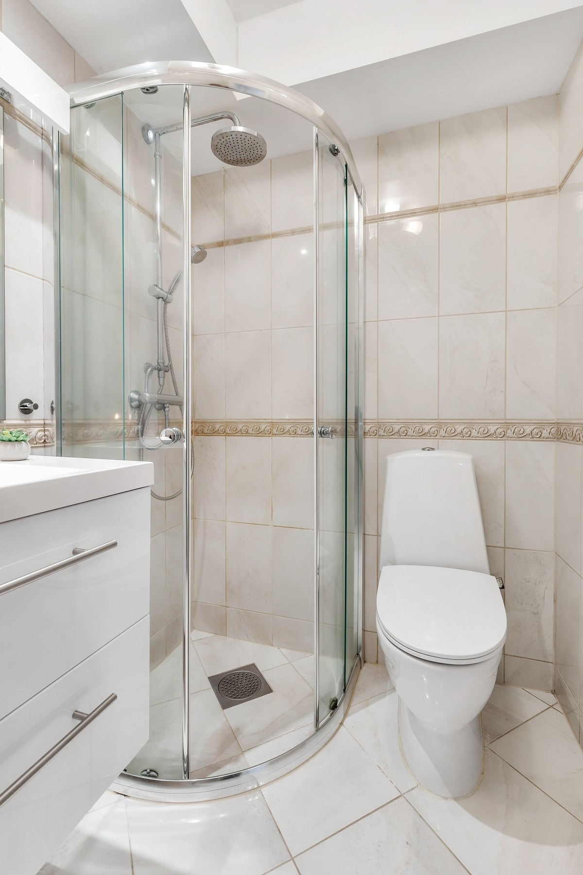 Videre har badet en dusjnisje med fast gulvprofil og skyvedører, samt gulvstående toalett Galleribilde