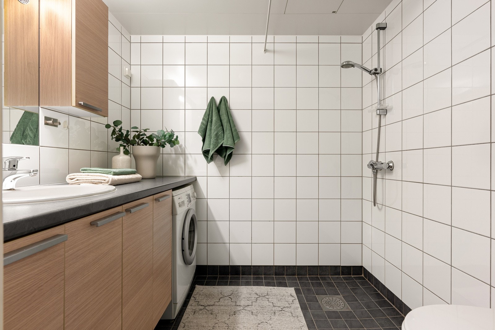 Badet er utstyrt med toalett, servant med speil og skapplass, dusjnisje, behagelig gulvvarme og opplegg for vaskemaskin. Galleribilde