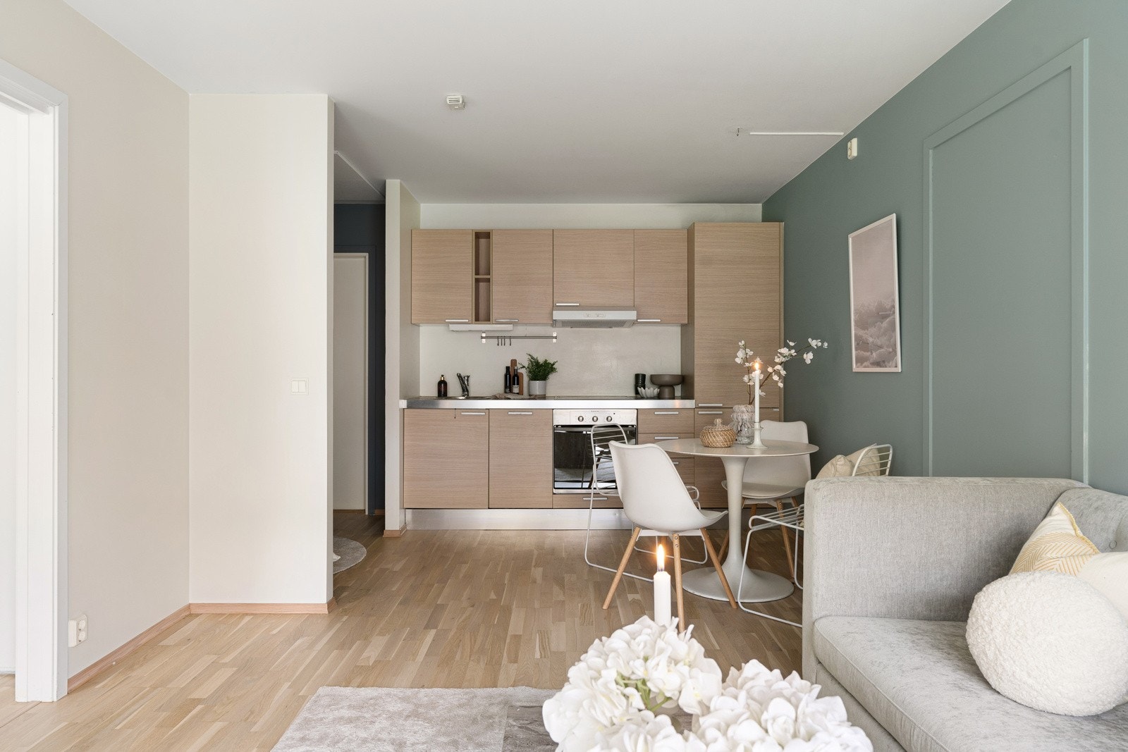 Leilighetens kjøkken er delvis tilbaketrukket i rommet og har en lys innredning kombinert med en mørkere benkeplate. Galleribilde