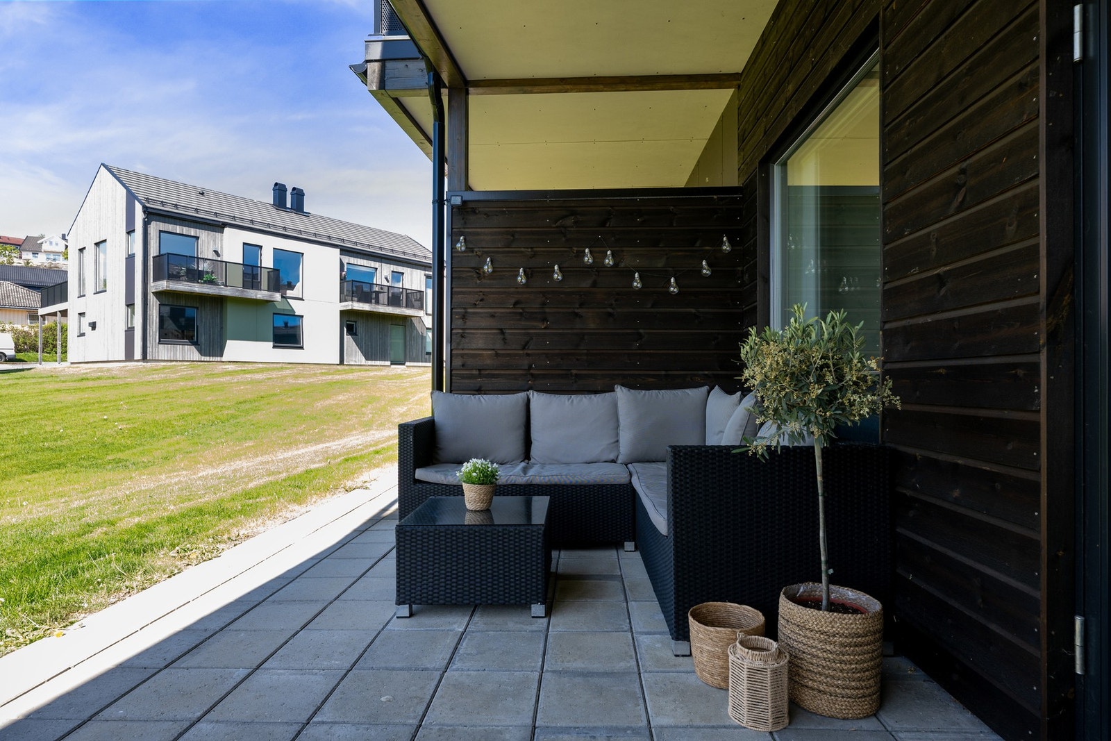 Plass til både sofa og spisegruppe på uteplassen. Her sitter man lunt og fint. Galleribilde