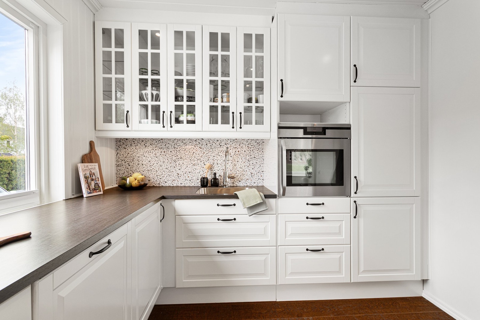 Pent kjøkken med godt med skap- og benkeplass. Integrerte hvitevarer som platetopp, stekeovn, oppvaskmaskin, vinskap og kjøl/fryseskap. Galleribilde