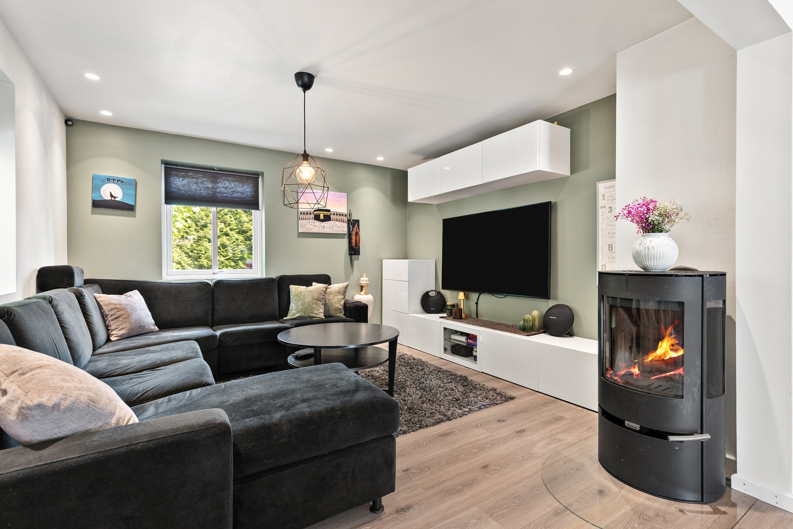 Innbydende stue med laminat på gulv og malte, slette flater på vegger og downlights i himling Galleribilde