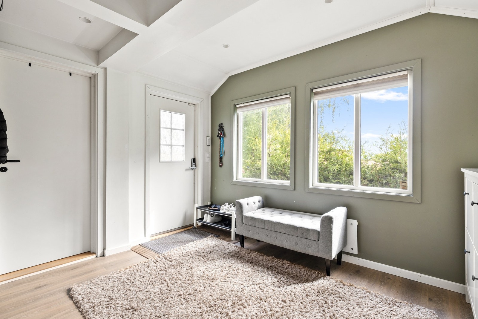 Lys og romslig entré med laminat på gulv, malte flater på vegger og downlights i himling Galleribilde