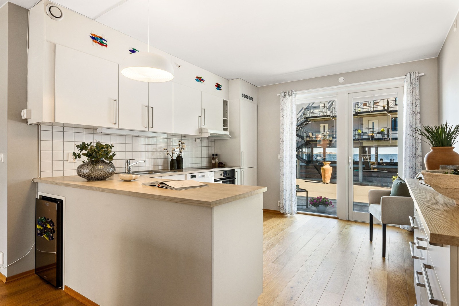 Lys og romslig stue med åpen løsning mot kjøkkenet. Store vindusflater slipper inn mye naturlig lys. Galleribilde