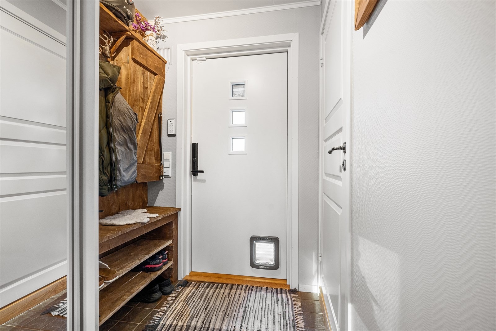 Hyggelig og innbydende entré med god plass til oppheng av klær og garderobeskap Galleribilde