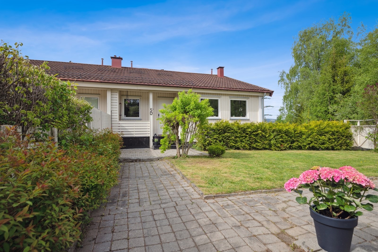 Adkomst til boligen med steinbelagt gangsti og hyggelig uteområde. Galleribilde