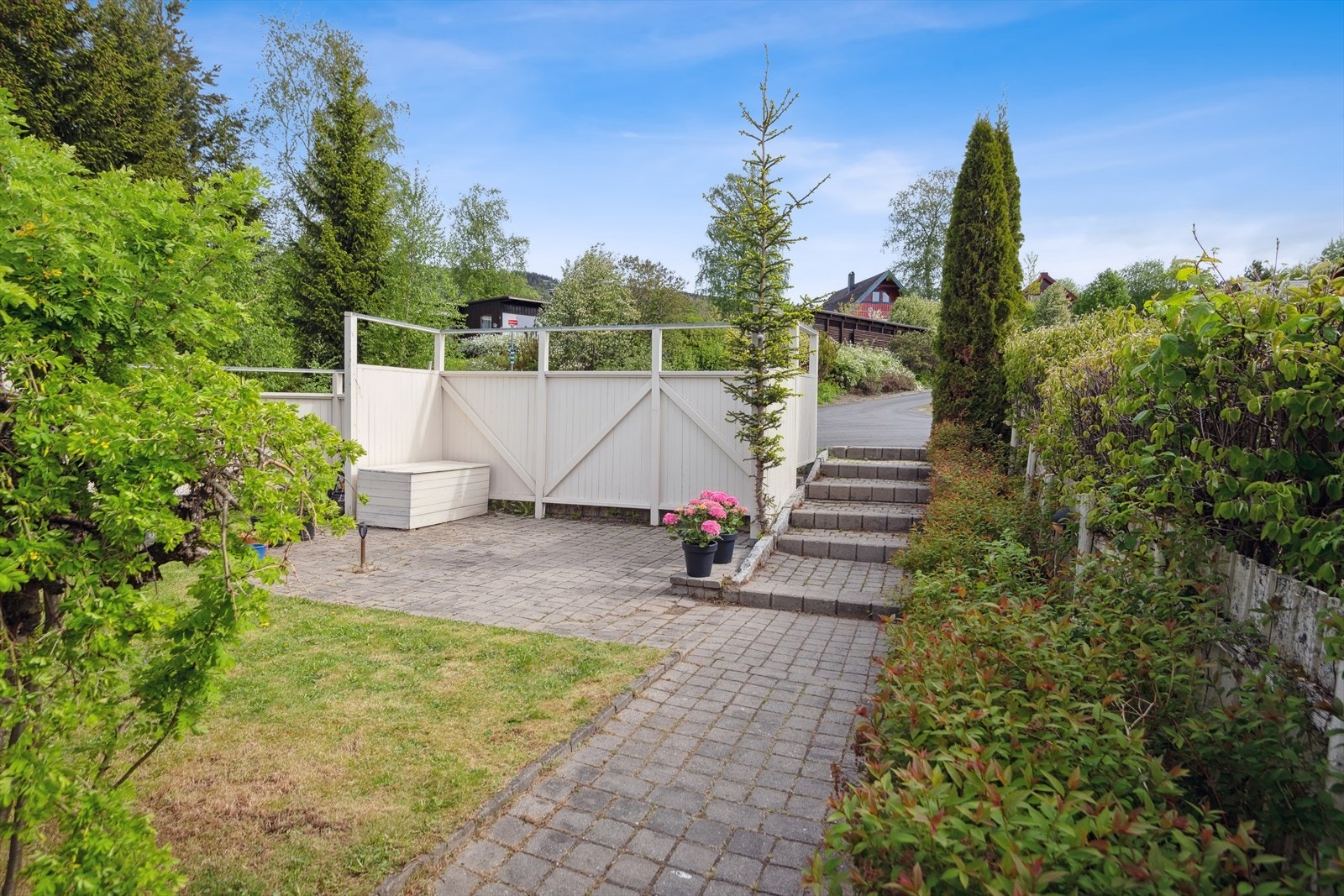 Hagen fremstår som en liten oase med morgensol og er skjermet for innsyn med tett gjerde og levegg. Galleribilde