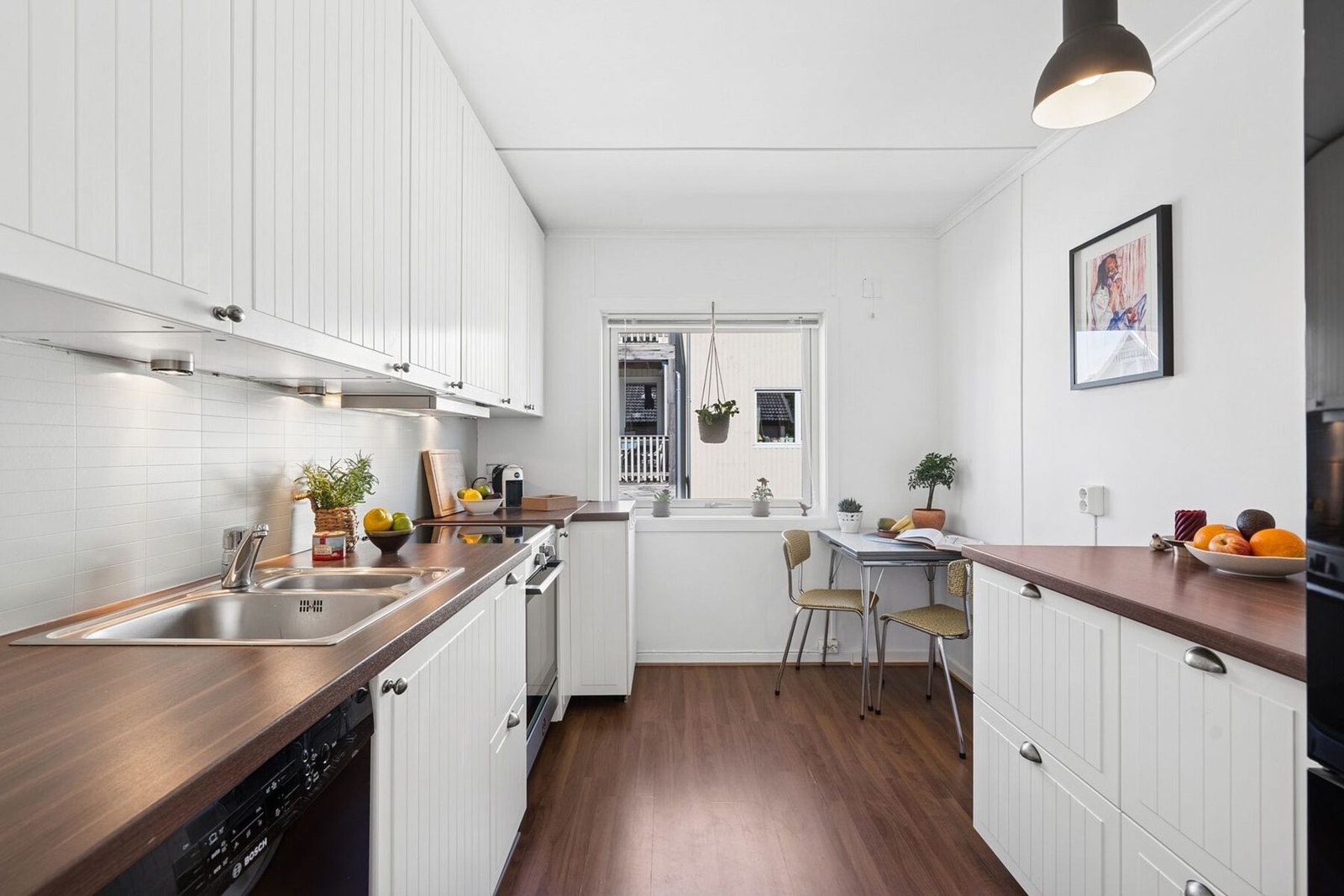 Det fine kjøkkenet fra 2009 har lys innredning med profilerte fronter og benkeplate av laminat. Galleribilde