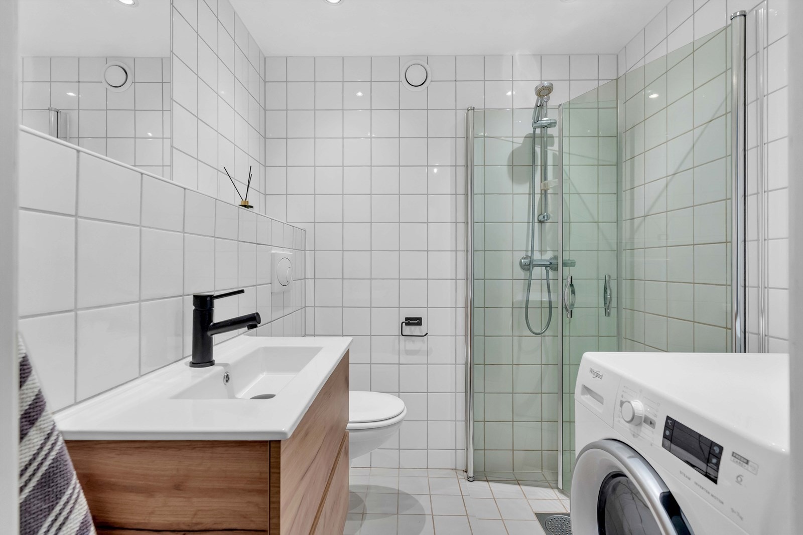 Delikat og tidløst bad med elektrisk gulvvarme. Badet består av ny servantinnredning, vegghengt toalett og dusjhjørne med innfellbare glassvegger. Galleribilde