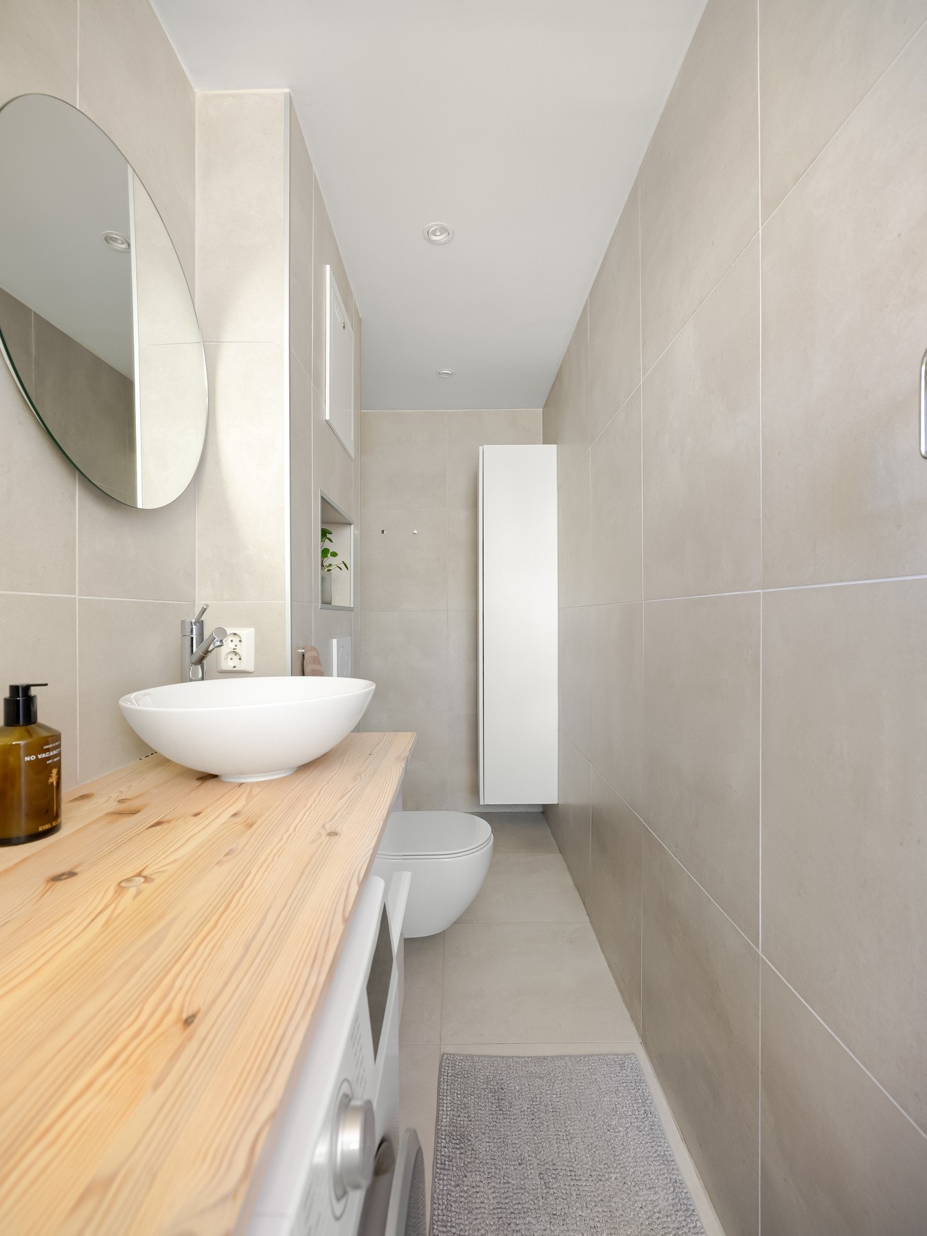 Badet er innredet med ovenpåliggende servant, speil med belysning, dusjhjørne med regndusj og vegghengt toalett. Galleribilde