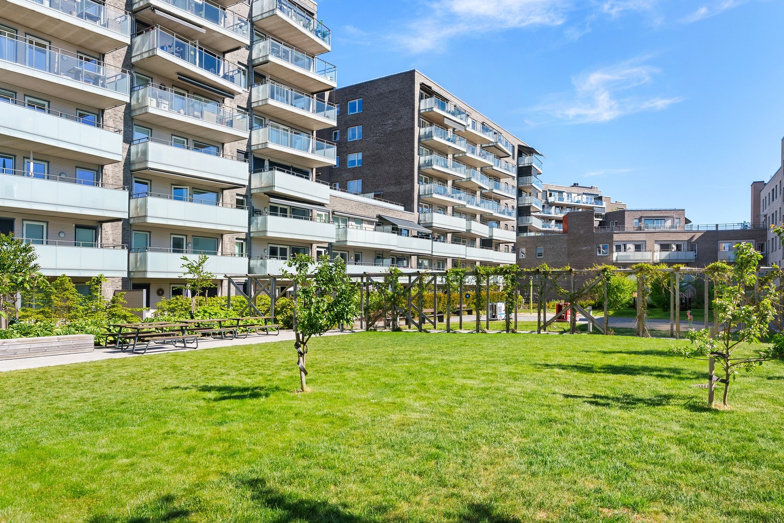 Gårdsrommet er avlåst og parkmessig opparbeidet med asfalterte internveier, store gressplener, sitteplasser og variert beplantning. Galleribilde