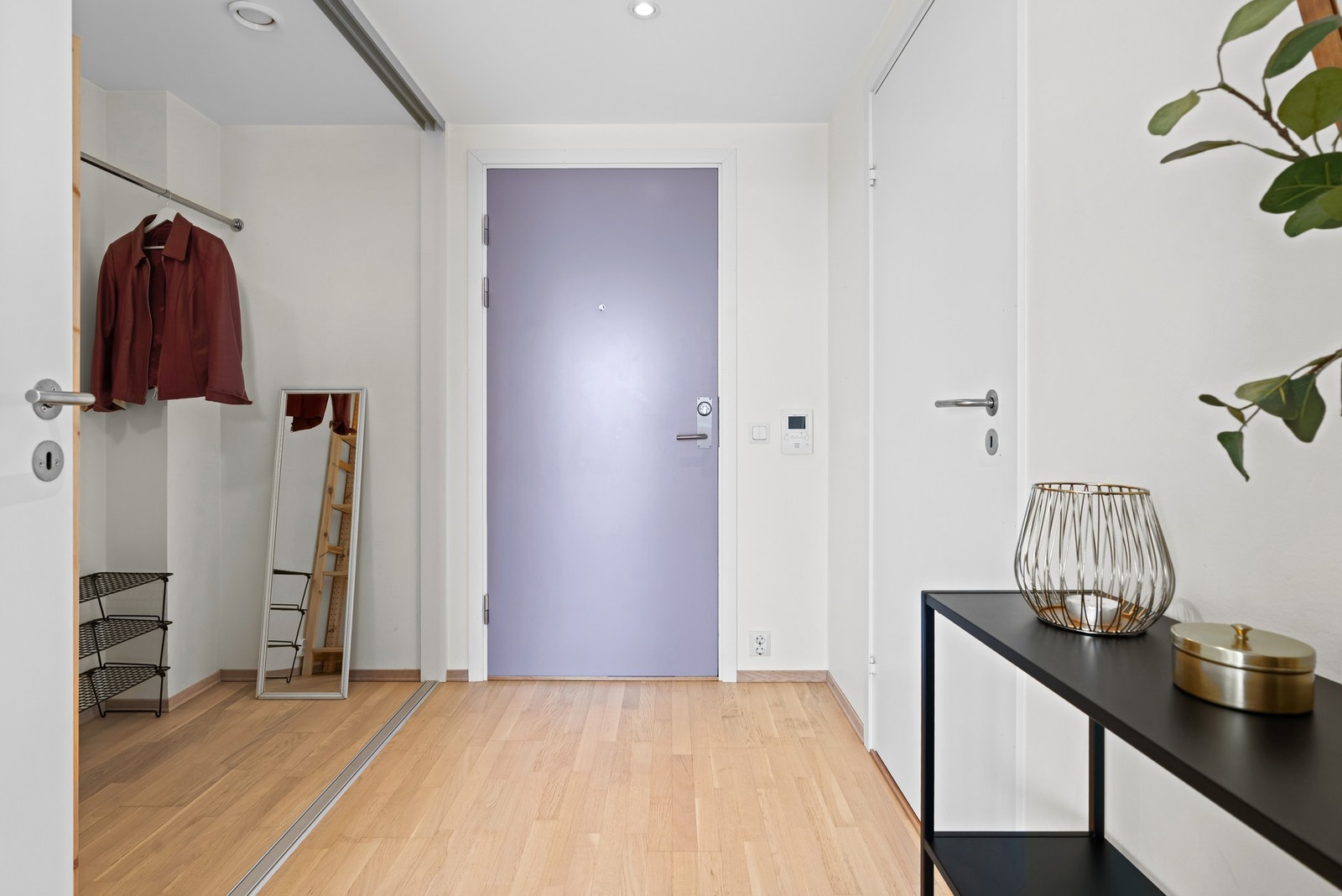 Entreen har parkett og hvitmalte overflater. Jakker og sko kan ryddes unna bak en stor skyvedør hvor det er rikelig med oppbevaringsplass. Galleribilde