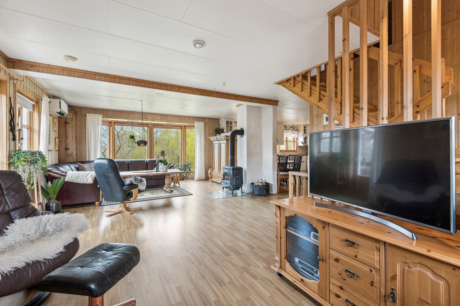 Stuen har store vindusflater som slipper inn godt med naturlig lysinnslipp. Boligen varmes opp med både vedfyring og en luft til luft varmepumpe. Galleribilde