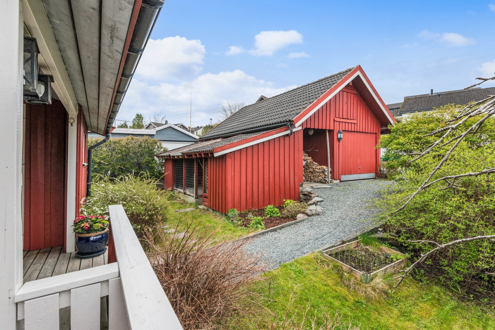 Utenfor huset har man garasje, hundegård og vedskjul Galleribilde