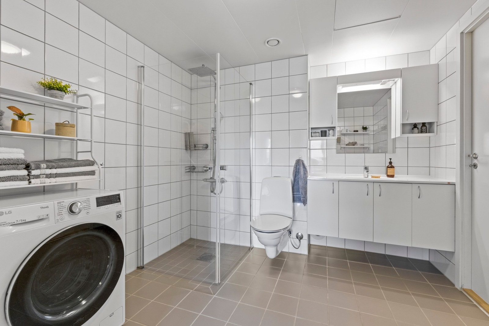 Baderommet har flislagte gulv og vegger, med termostatstyrte varmekabler i gulvet. Dusjhjørne med svingdører og regndusj. Galleribilde