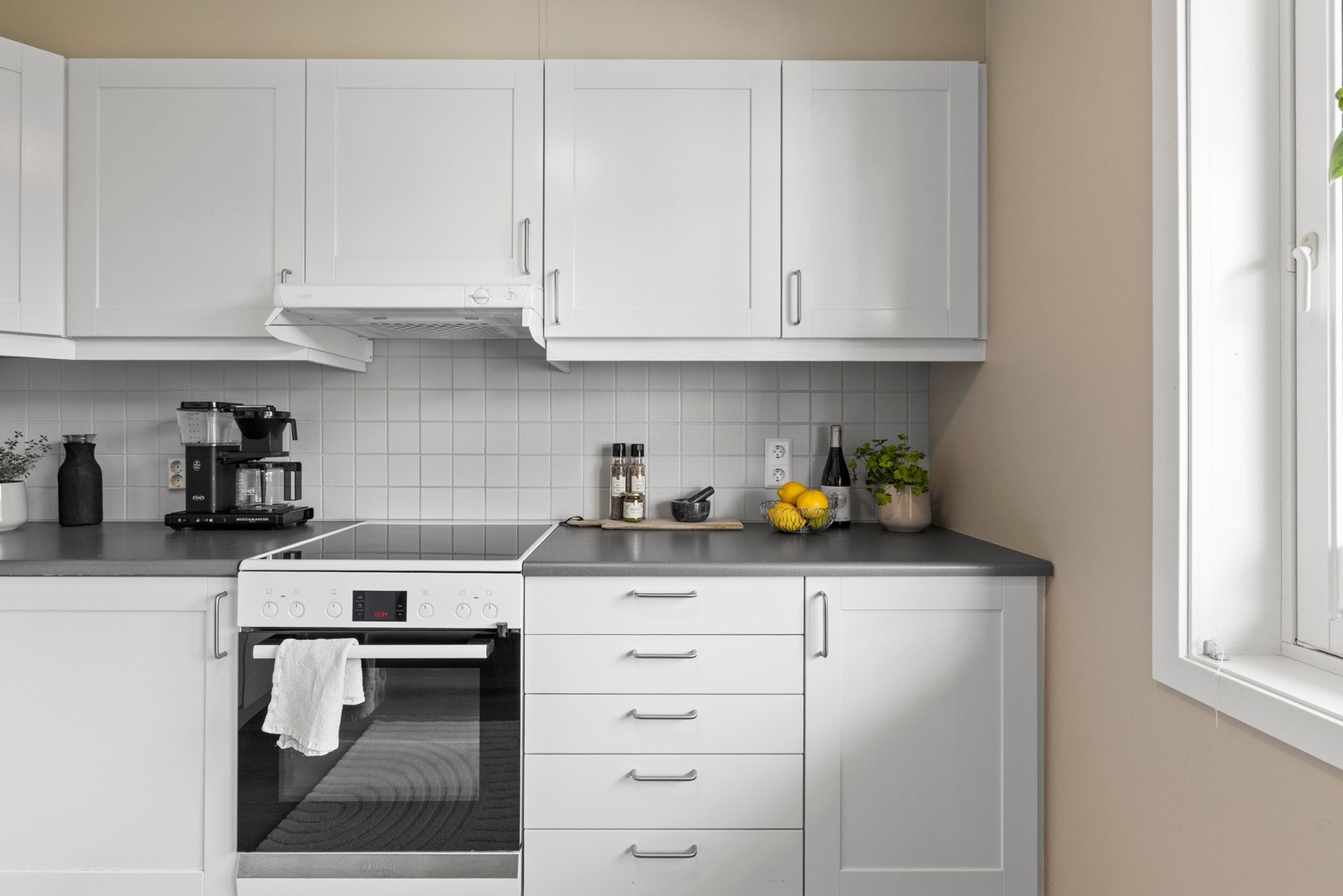 Det er fliser på veggen overbenkeplate med belysning under overskapene. Du har komfyr med platetopp, opplegg for oppvaskmaskin og frittstående kjøl/fryseskap. Galleribilde