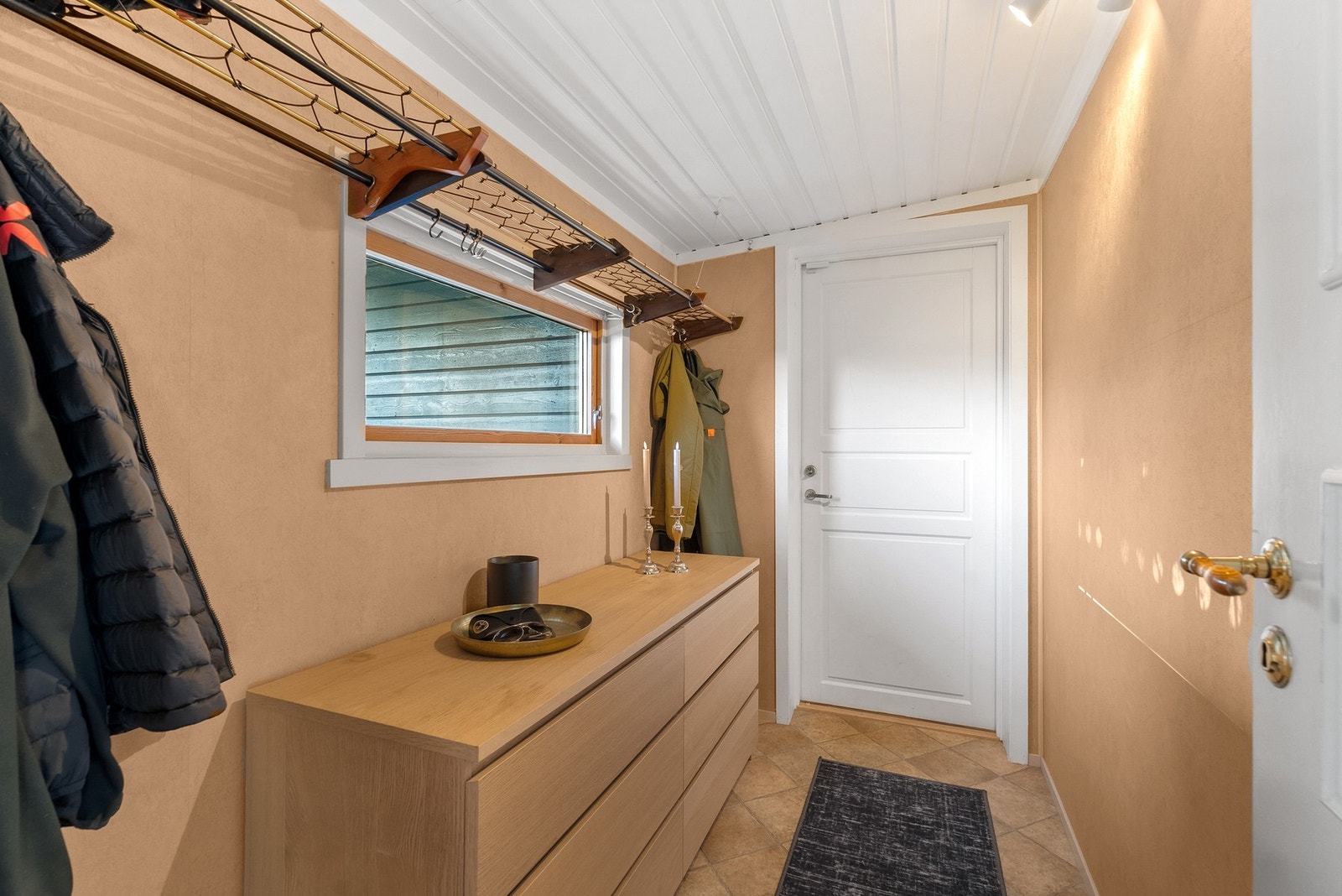 Praktisk gjennomgang mellom huset og garasjen, her finner man også ytterligere oppbevaringsplass. Galleribilde