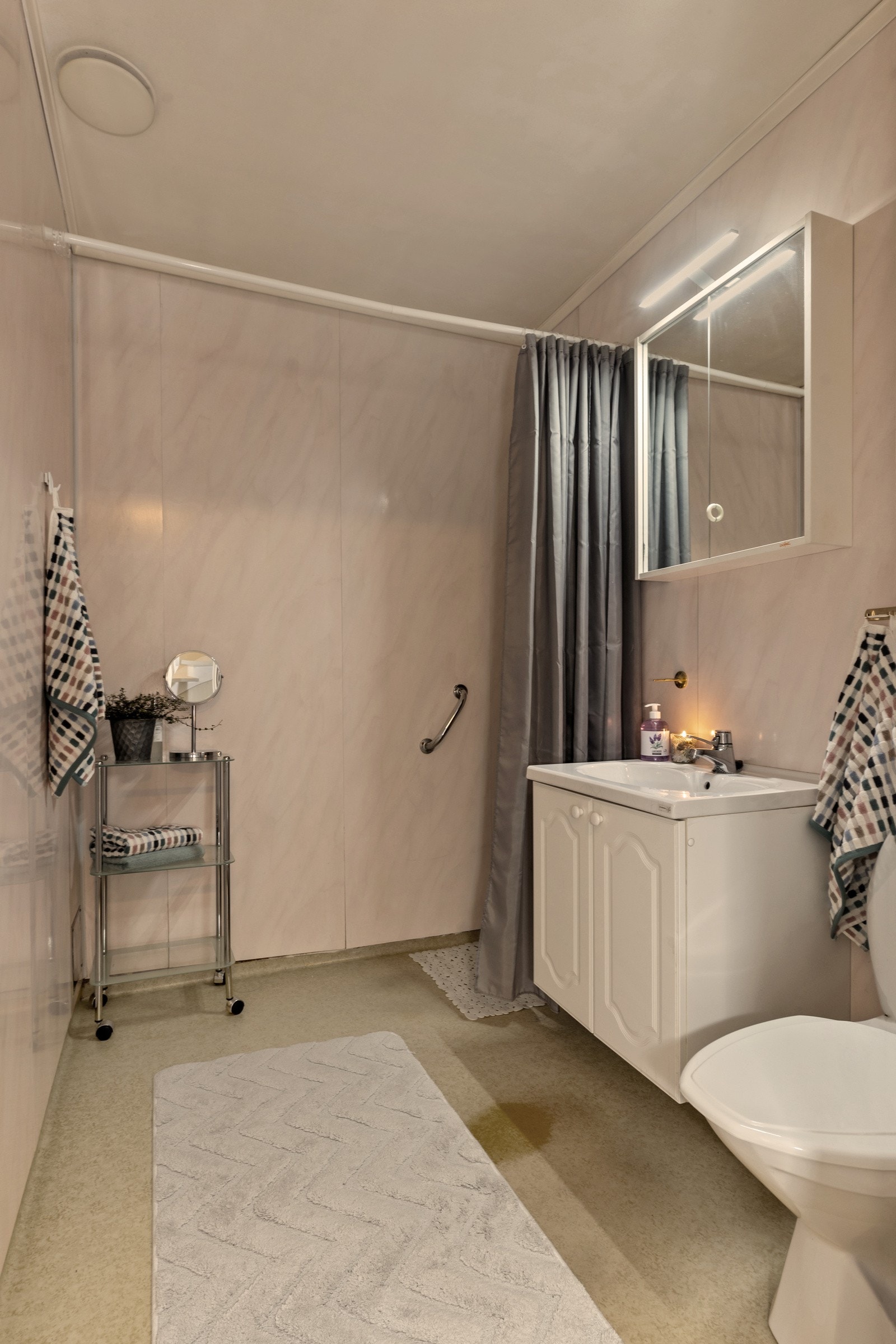 Badet er innredet med nedfelt servant, gulvfestet toalett og dusjhjørne. Selv om badet er av eldre dato, vitner det om et potensial for de som ønsker å sette sitt personlige preg på oppdateringer! Galleribilde