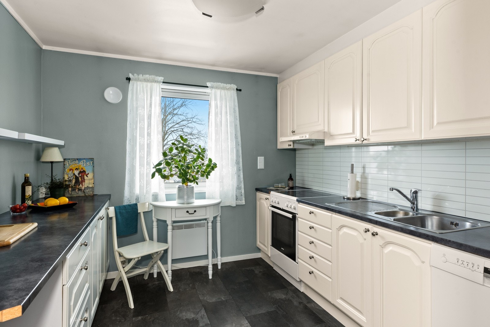 Kjøkkenet byr på en funksjonell atmosfære med slette fronter, slitesterk laminat benkeplate og integrerte hvitevarer Galleribilde