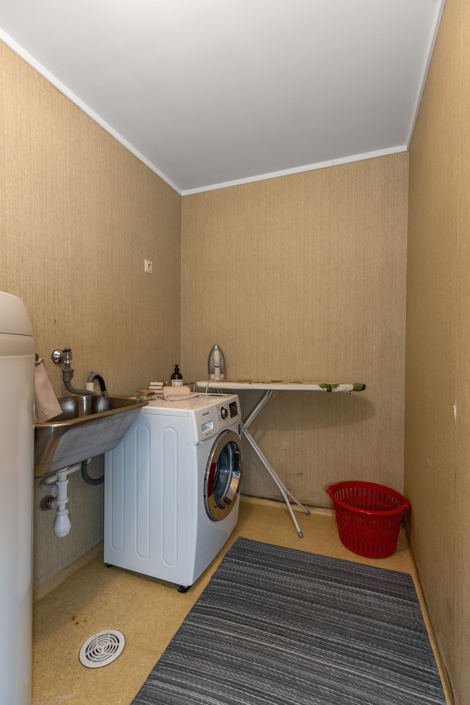 Separat vaskerom utstyrt med utslagsvask og opplegg for vaskemaskin Galleribilde