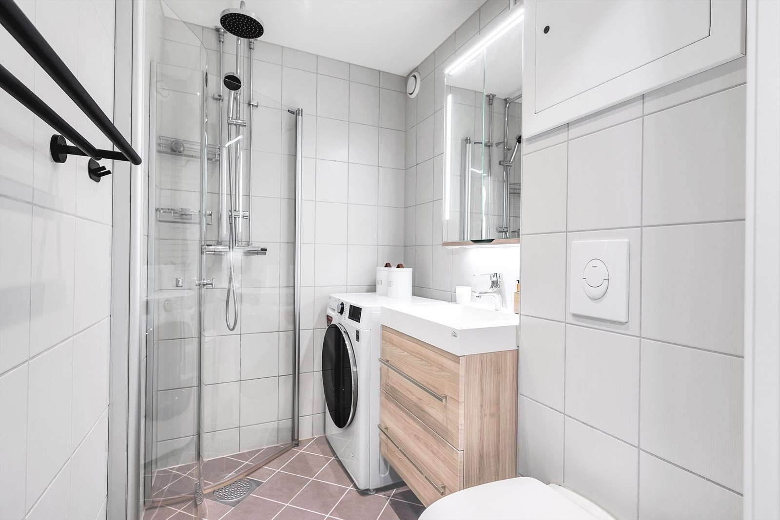 Bad med dusjkabinett, vaskemaskin og moderne innredning. Galleribilde