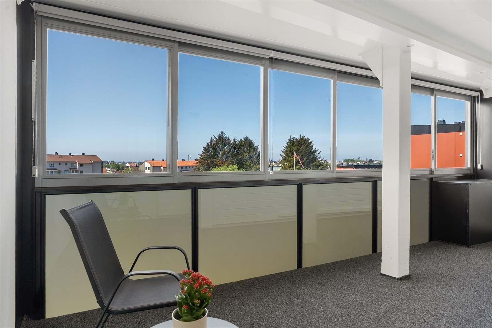 Stor, innglasset balkong med god plass til utemøblement Galleribilde