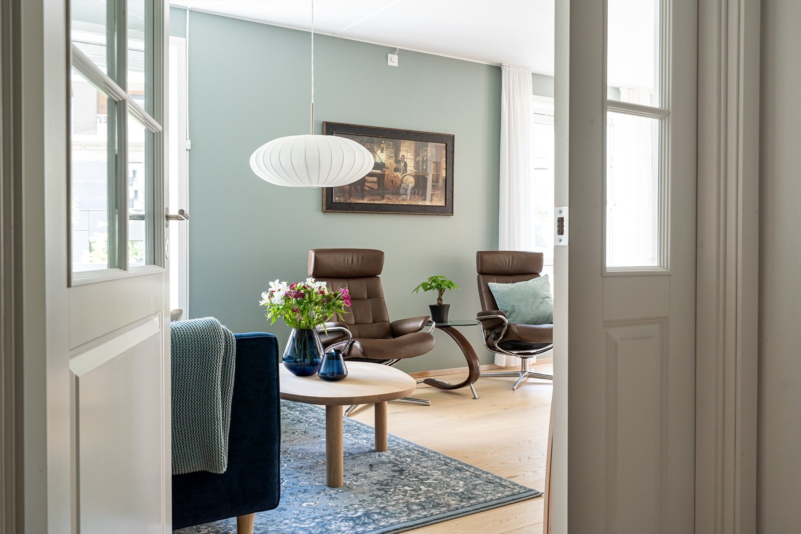 Døren mellom gangen og stuen har elegante glass som slipper lyset gjennom. Galleribilde