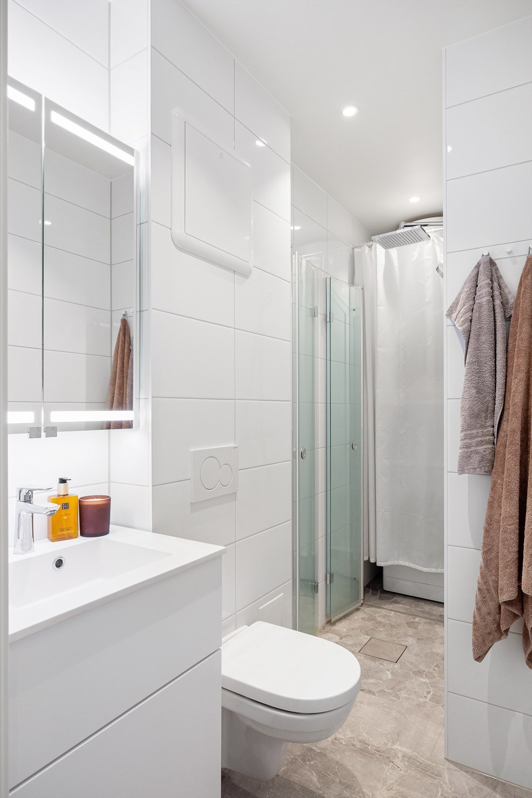 Badet har behagelig gulvvarme og downlights i himlingen, og er innredet med vegghengt toalett, dusjnisje med glassvegger og servant med ettgreps blandebatteri i innredning. Galleribilde