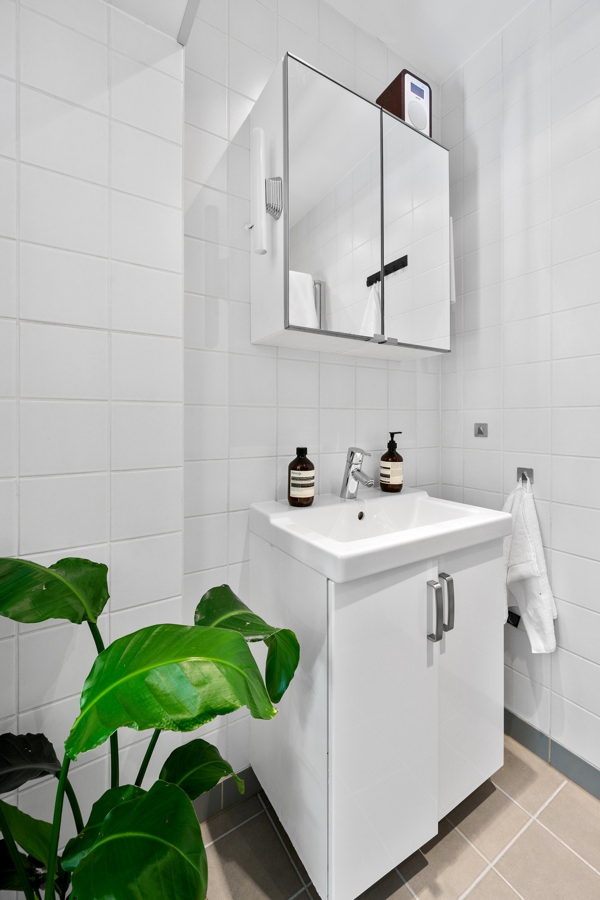 Rommet er innredet med en vask med innredning og speil, dusjhjørne og opplegg til vaskemaskin. Galleribilde