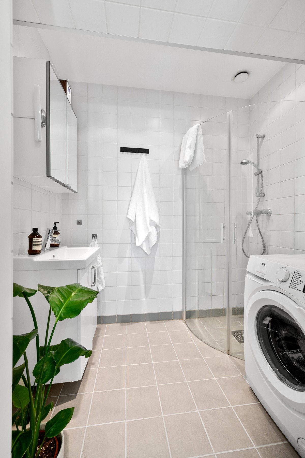 Kombinert flislagt bad og vaskerom med varmekabler. Galleribilde