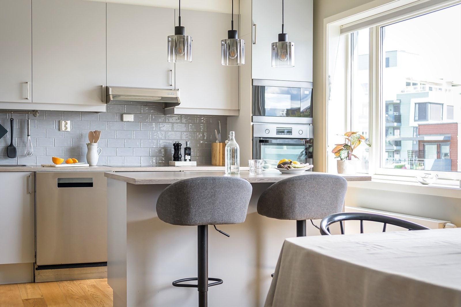 Kjøkkeninnredning med laminert benkeplate med nedfelt oppvaskkum med 1-greps blandebatteri, og fliser mellom over og underskap. Galleribilde