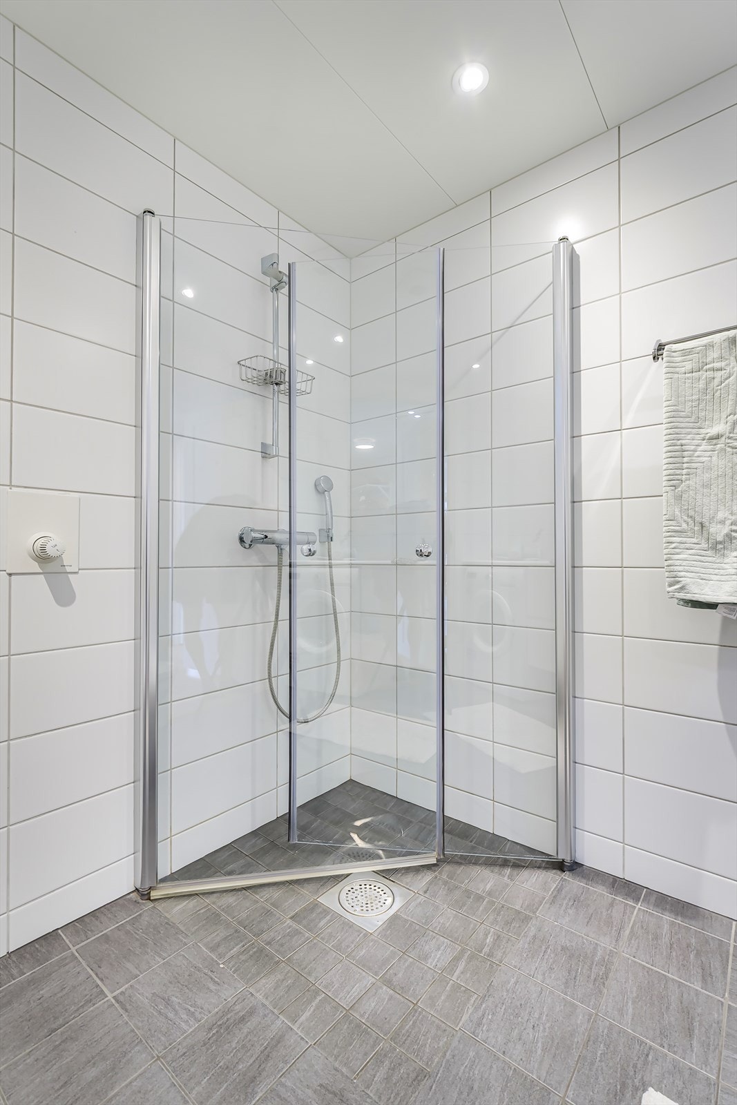 Badet er flislagt og innredet med servant i benkeplate med skuffer og opplegg for vaskemaskin og tørketrommel. Galleribilde