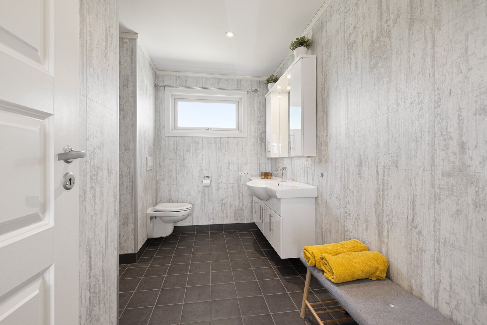 Baderommet er fra 2014 med flislagte flater på gulv og baderomsplater på vegg Galleribilde