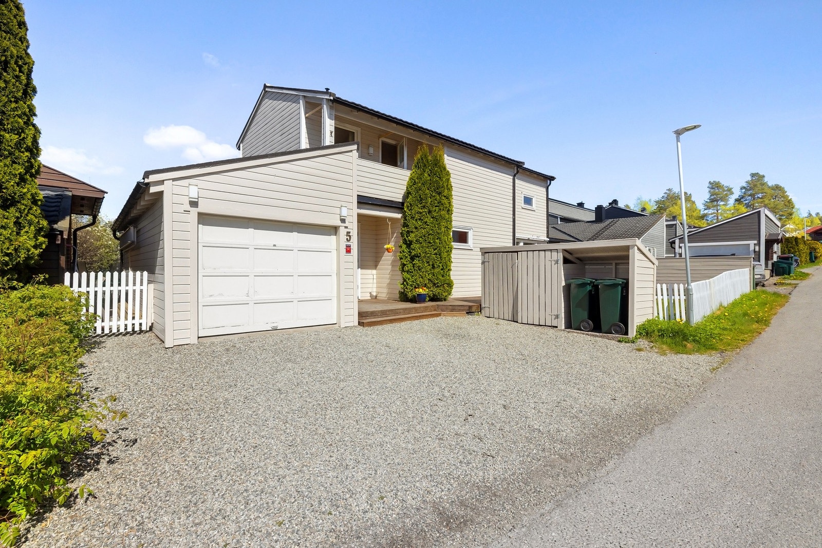 Huset har parkering i garasje med elbilader i tillegg til stor grusbelagt biloppstilling Galleribilde