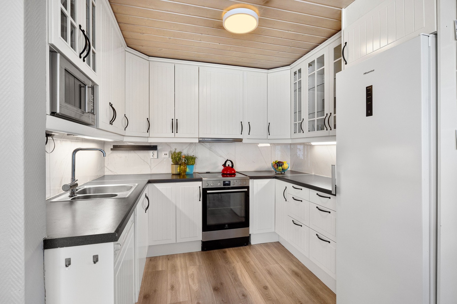 Kjøkkeninnredning er med med klassiske hvite profilerte fronter og benkeplate i laminat Galleribilde