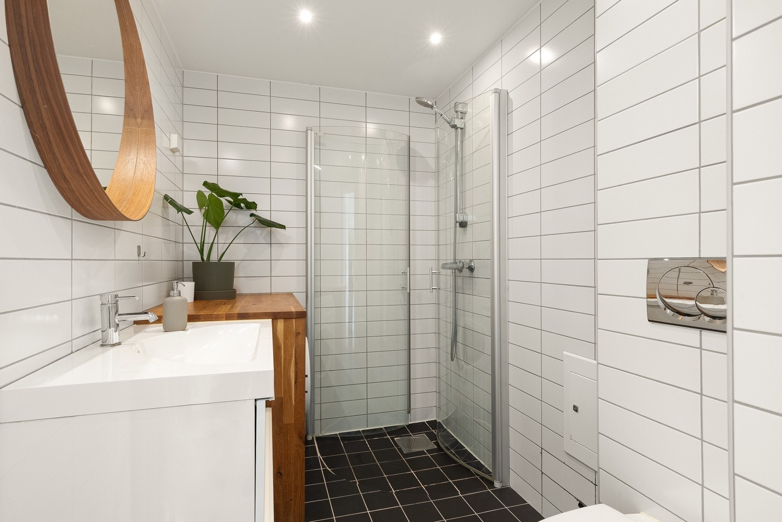 Delikat og tidløst baderom fra 2007 som inneholder dusjhjørne, servantskap med heldekkende servant, vegghengt toalett, opplegg for vaskemaskin. Galleribilde