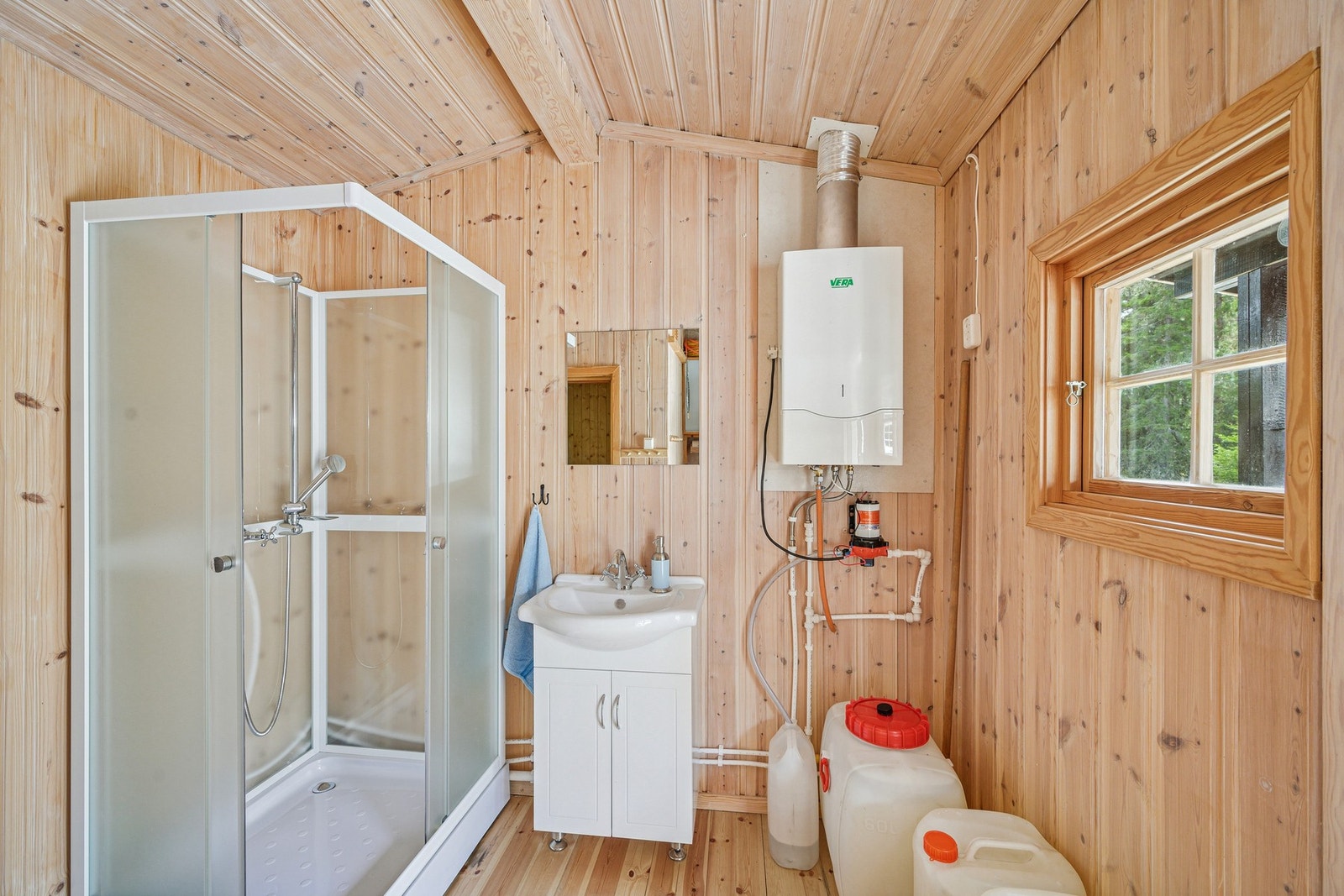 Det er installert dusjkabinett med 12-volts pumpe koblet til vanndunk, som sender vann gjennom en gjennomstrømnings varmer før det ledes som gråvann direkte ut i grunnen. Galleribilde