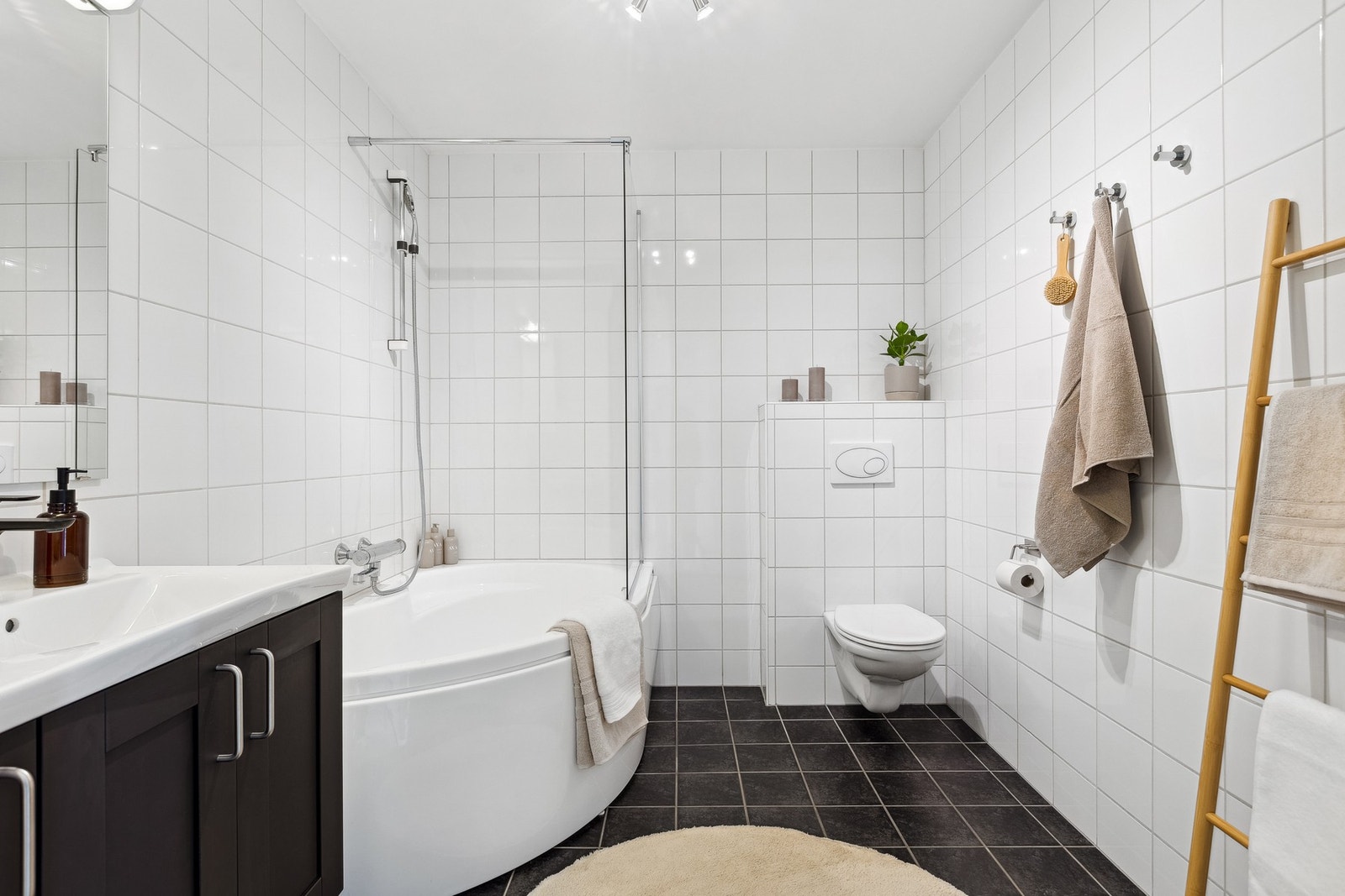 Utstyrt med mekanisk avtrekk, badekar med vegghengt badekararmatur, servant i servantskap og veggehengt toalett. Galleribilde