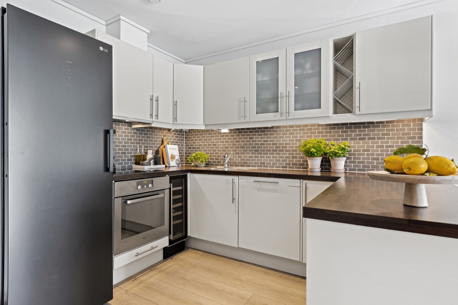 Åpen kjøkkenløsning med innredning med glatte fronter, integrerte hvitevarer. Galleribilde