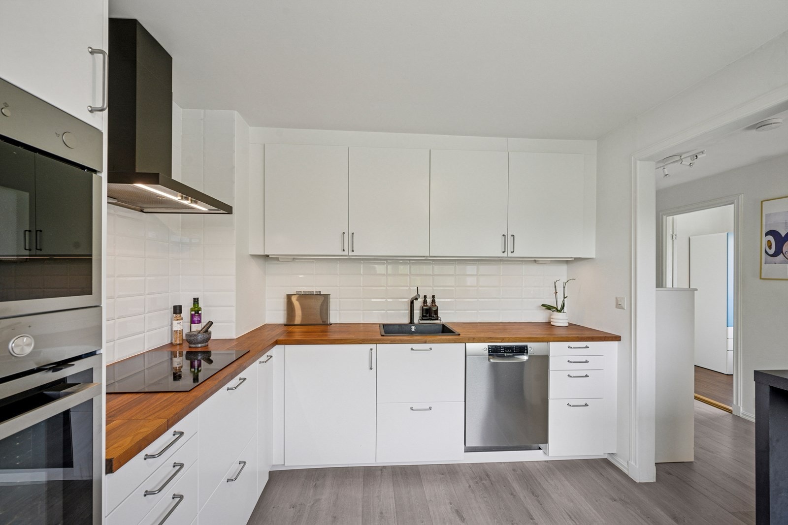 Innredningen har glatte fronter som gir et rent og tidløst uttrykk, mens belysning under overskapene skaper både stemning og god arbeidslys. Galleribilde