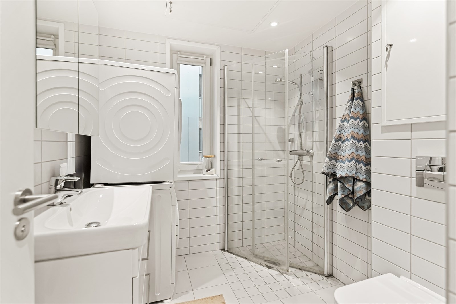 Helflislagt bad med vegg- og gulvfliser. Elektriske varmekabler i gulv gir en lun varme året rundt. Badet er utstyrt med servantskap, samt overhengende speil med lys. Galleribilde