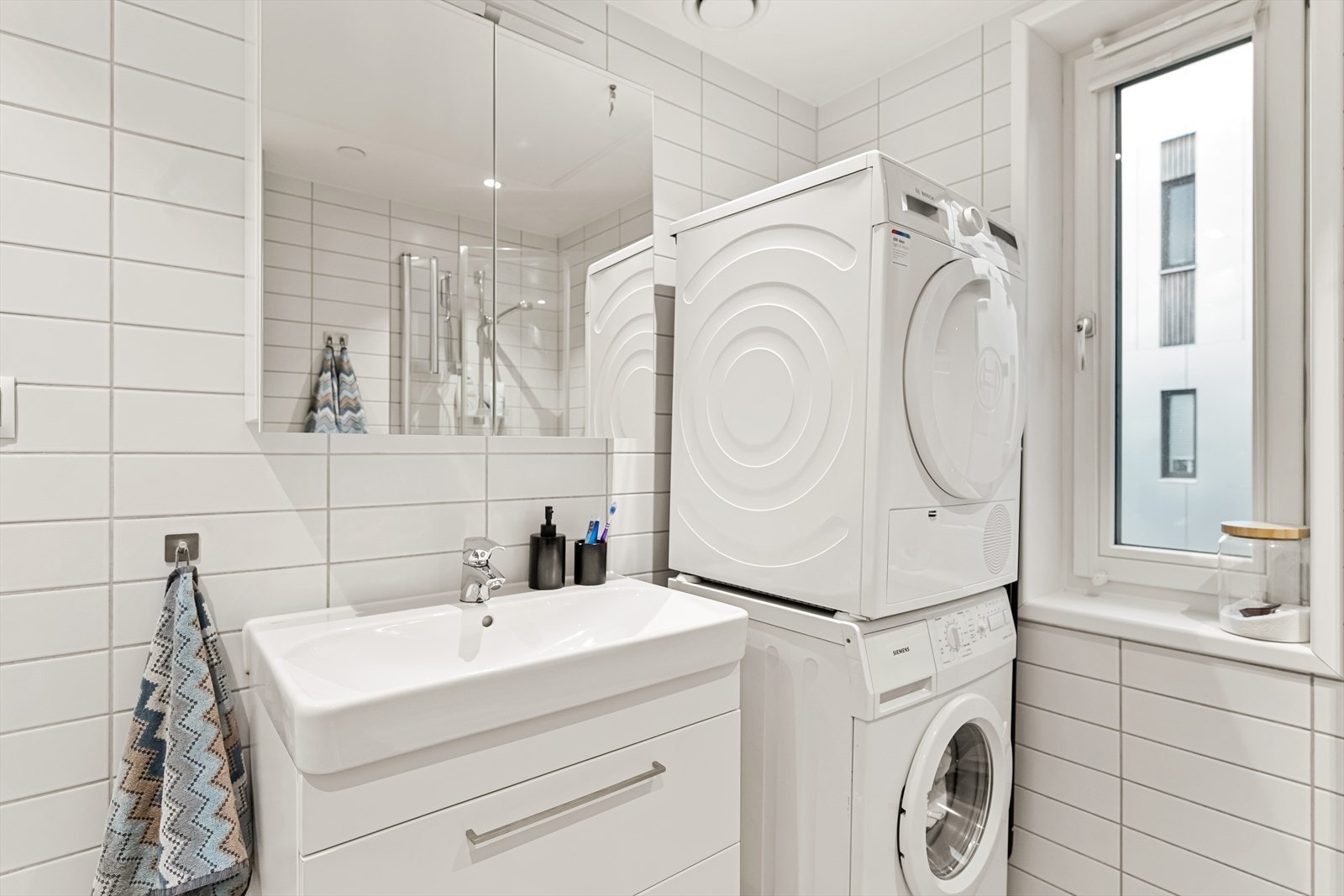 Videre er det vegghengt toalett og dusjsone med inn- og utfeltbare dusjvegger. Det er opplegg for vaskemaskin og tørketrommel. Badet har også vindu som gir naturlig lys og god ventilasjon. Galleribilde