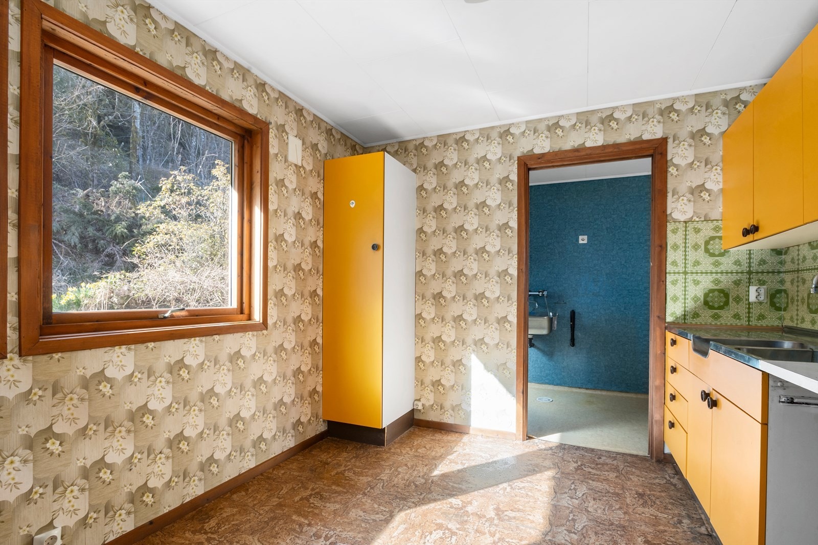 Kjøkken i 1. etasje med mye skap- og benkplass. Eldre kjøkkeninnredning med standard fra byggeår. Galleribilde