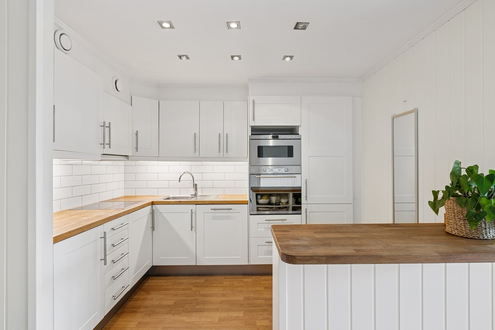 Kjøkkenet fremstår lyst og pent, med glatte fronter og benkeplate i heltre som gir et varmt uttrykk. Galleribilde