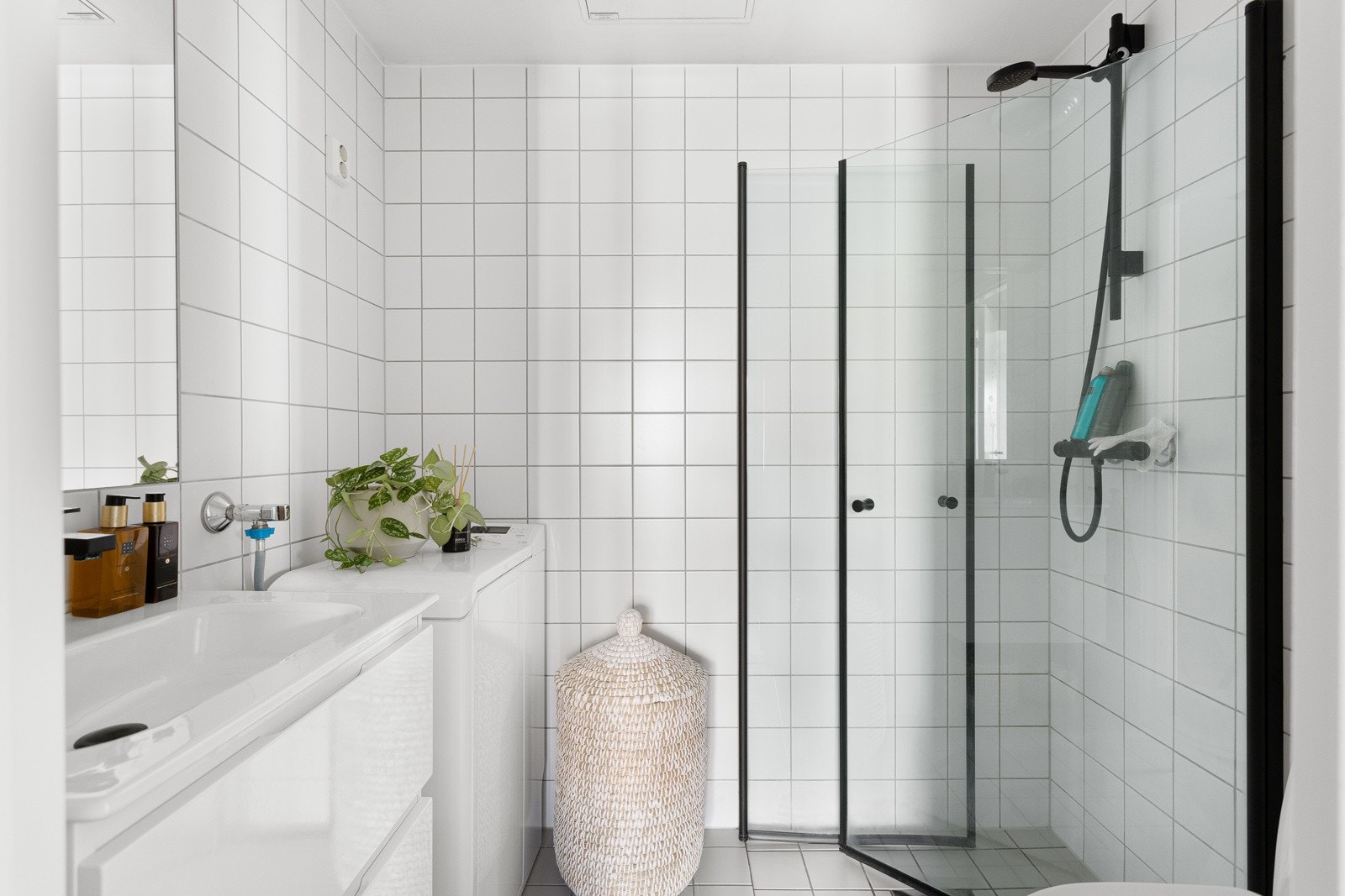 Baderommet har lysegrå fliser på gulv, deilig gulvvarme, hvite fliser på veggene og mekanisk avtrekk. I hjørnet av badet er det plass og opplegg for vaskemaskin. Galleribilde