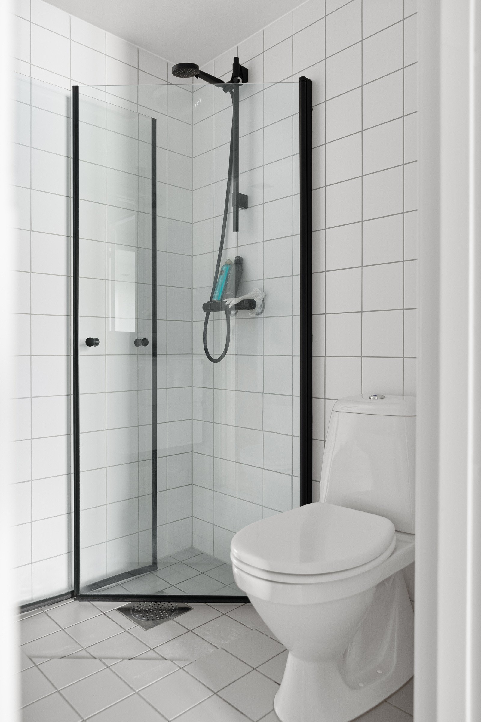 Baderommet er også utstyrt med dusjhjørne med innfellbare glassdører og sort dusjarmatur, samt toalett. Galleribilde